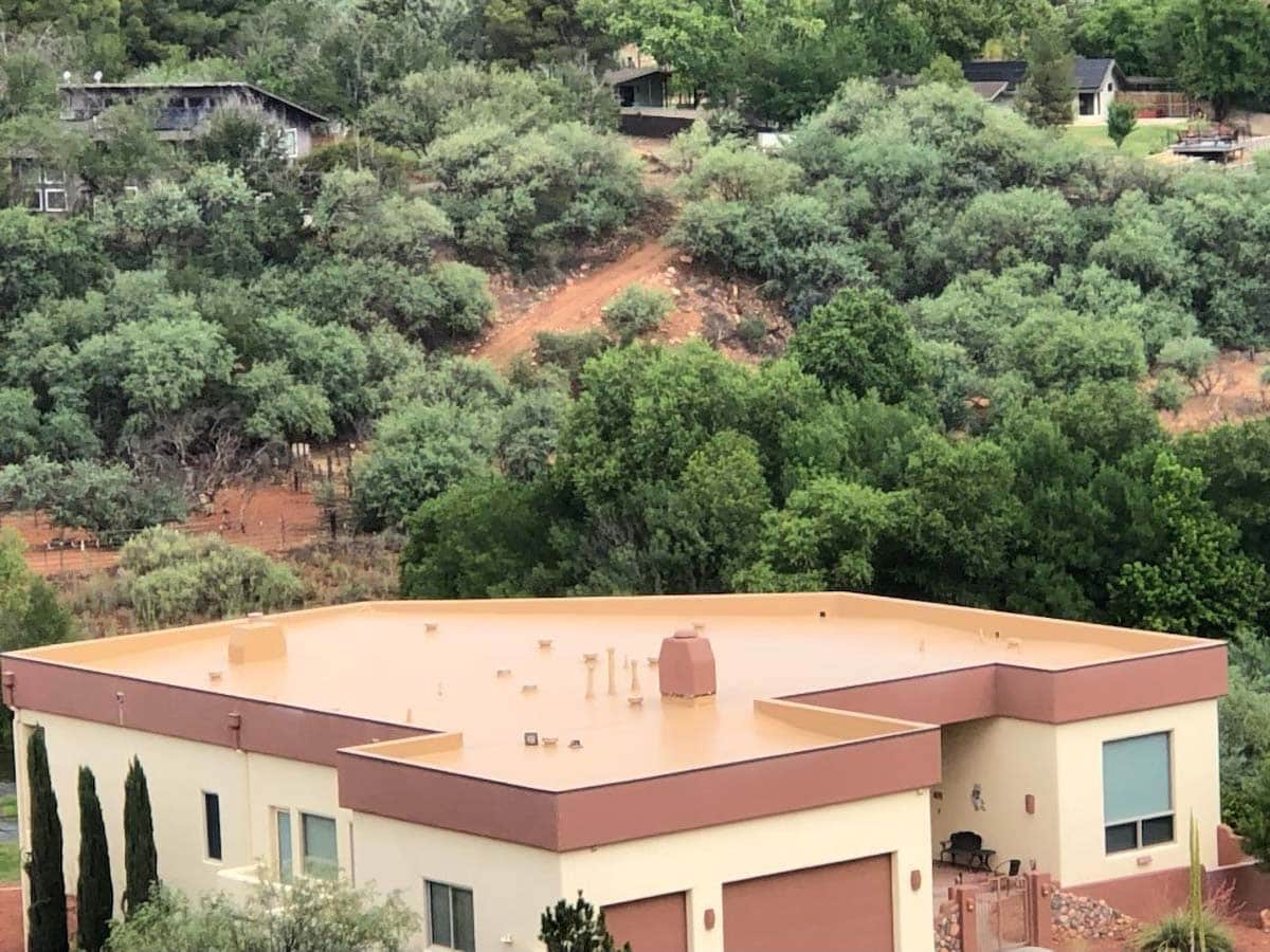 Residential home featuring flat roofs in Arizona surrounded by trees and hillside terrain