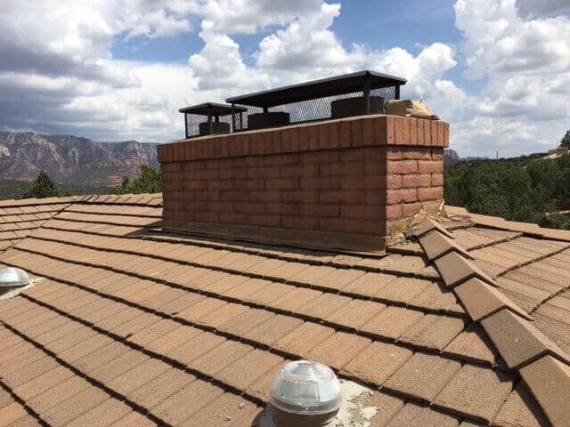 Tile Roofing around a large brick chimney