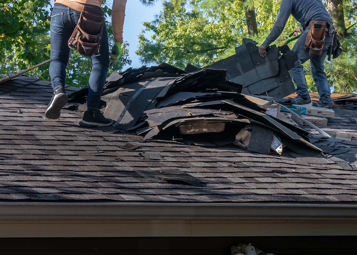 Roofers repairing a roof after hail damage