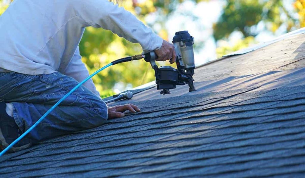 worker installing a metal shingle roof