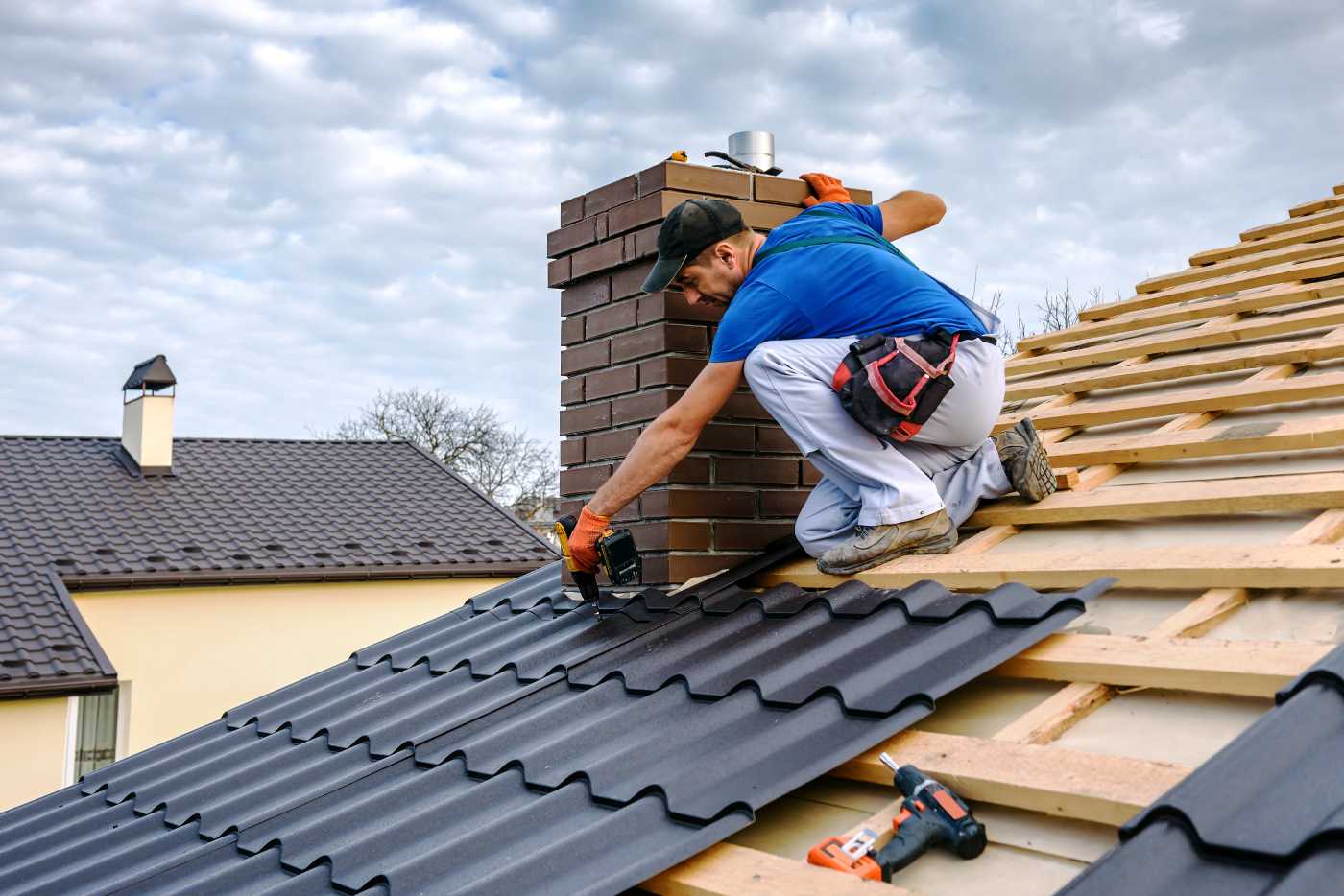 Roofing contractor at work securing metal roof tiles