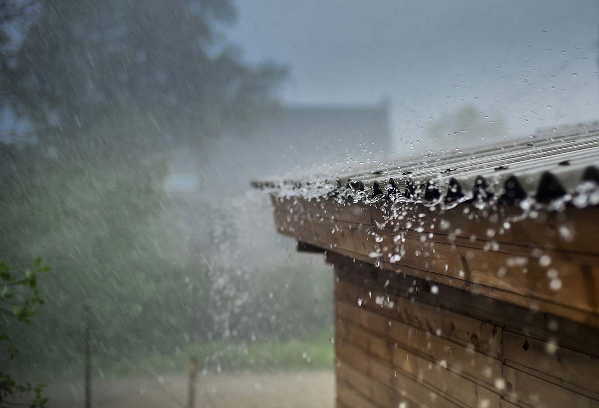 Close-up of rain on a corrugated metal roof, showcasing the potential for noisy precipitation impact.