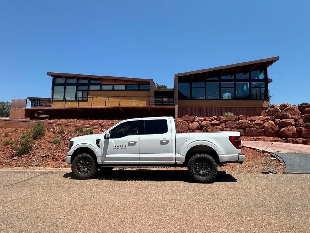 Han Roofing truck in front of a moder house with custom roofing and siding in Sedona Arizona