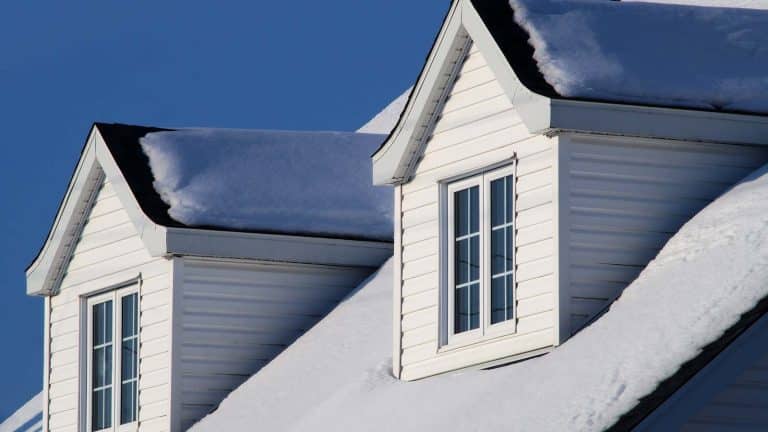 A snow-covered white house in Prescott Valley, emphasizing winterizing techniques. From the blog post "How to Winterize Your Roof in Prescott Valley" by Hahn Roofing.