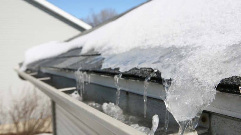 A Prescott Valley home with icy gutters and a snow-covered roof, emphasizing winter roof protection strategies. From the blog post "Winter Roof Protection Tips for Prescott Valley Homeowners" by Hahn Roofing