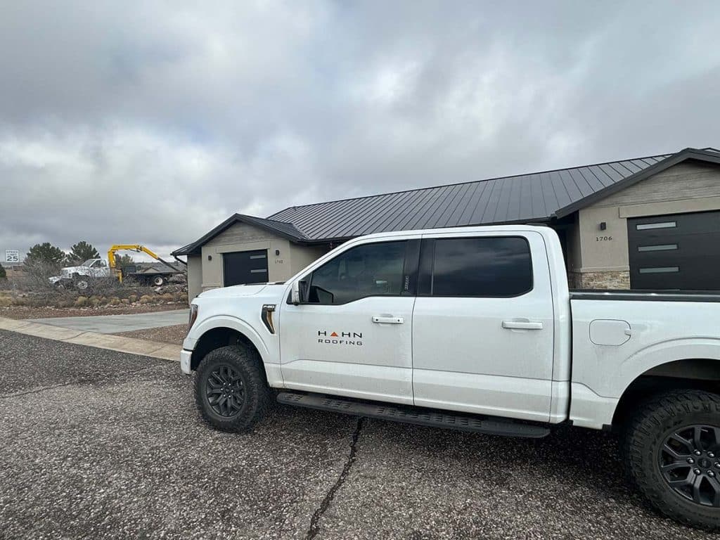 A work truck with the Hahn Roofing logo parket at a job site in Cottonwooed, AZ